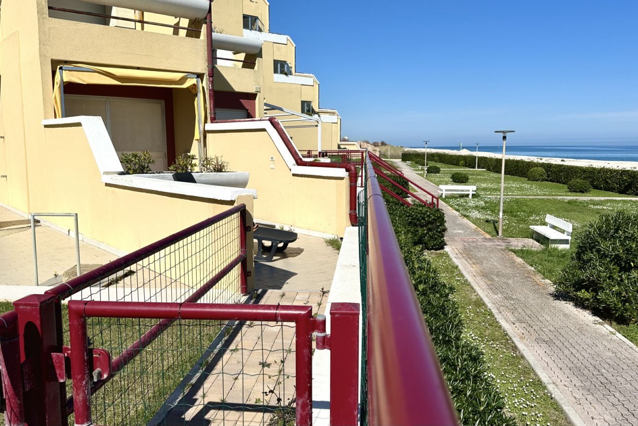 Un bâtiment doté d’une rambarde rouge, d’un chemin pavé et d’un banc.