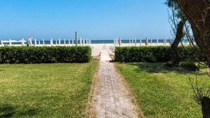 A paved pathway leading to a beach with white fencing and a clear view of the ocean. - SE068 - Senigallia, two-room apartment on the sea at the Piramidi residence (Senigallia)