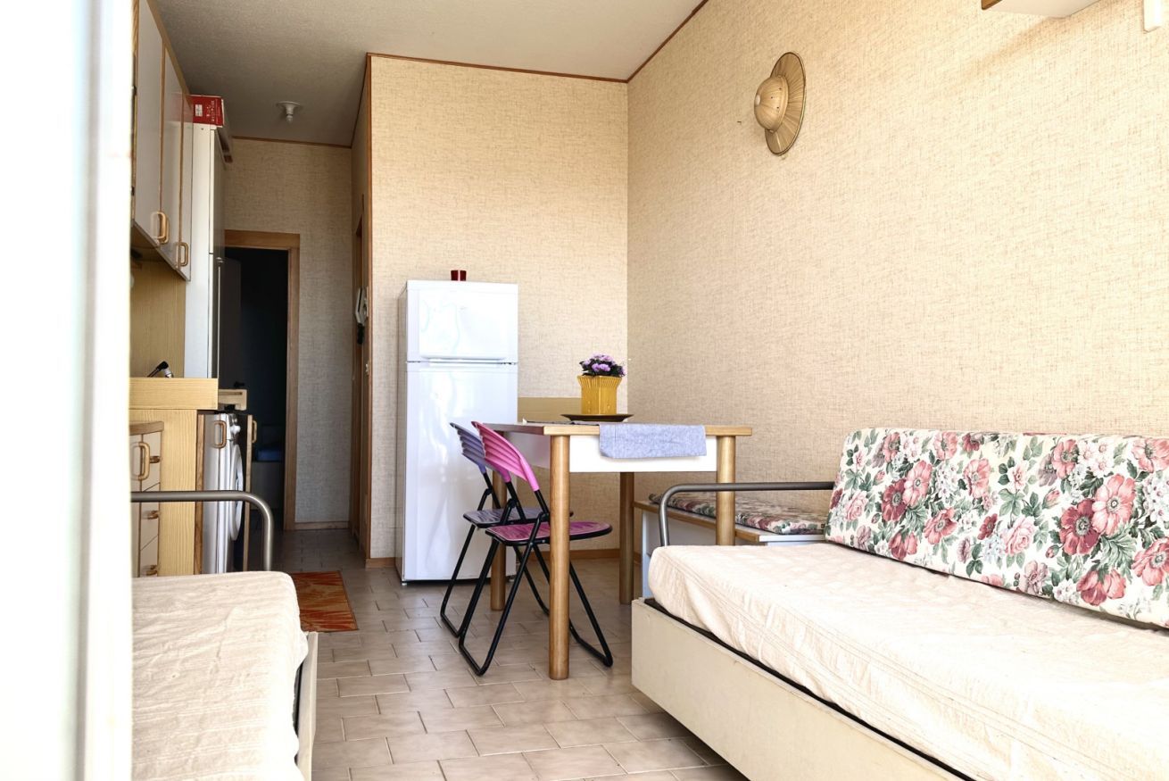 Une pièce de taille modeste comprenant un lit, une petite kitchenette, une table à manger et une chaise.