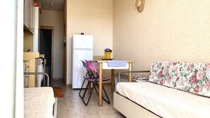 A compact room with a bed, a small kitchenette, a dining table, and a chair. - SE068 - Senigallia, two-room apartment on the sea at the Piramidi residence (Senigallia)