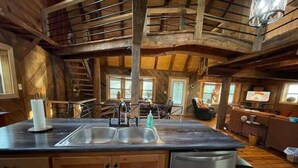 Une cuisine rustique avec des meubles en bois, un évier à deux bacs et un lave-vaisselle.