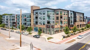 A multi-story building with a modern architectural design, featuring balconies, large windows, and a ground-level restaurant. - Sleepover | Prime 1BD/1BA - Downtown Des Moines (Des Moines)