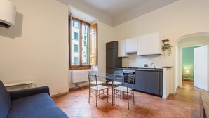 Um espaço compacto com cozinha compacta, área de refeições e sofá.