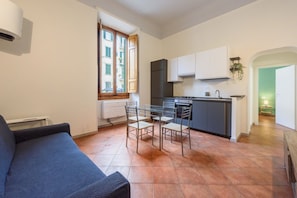 A compact living space with a kitchenette, a dining area, and a sofa.