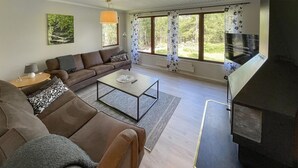 Uma sala de estar moderna com sofá, mesa de centro e lareira.