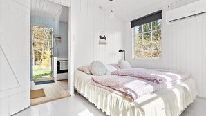 Un dormitorio con una cama, una ventana y una puerta que da a una cocina.