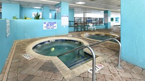 Un espace avec un bain à remous, agrémenté d’un panneau indiquant : « Aucun sauveteur de service. »