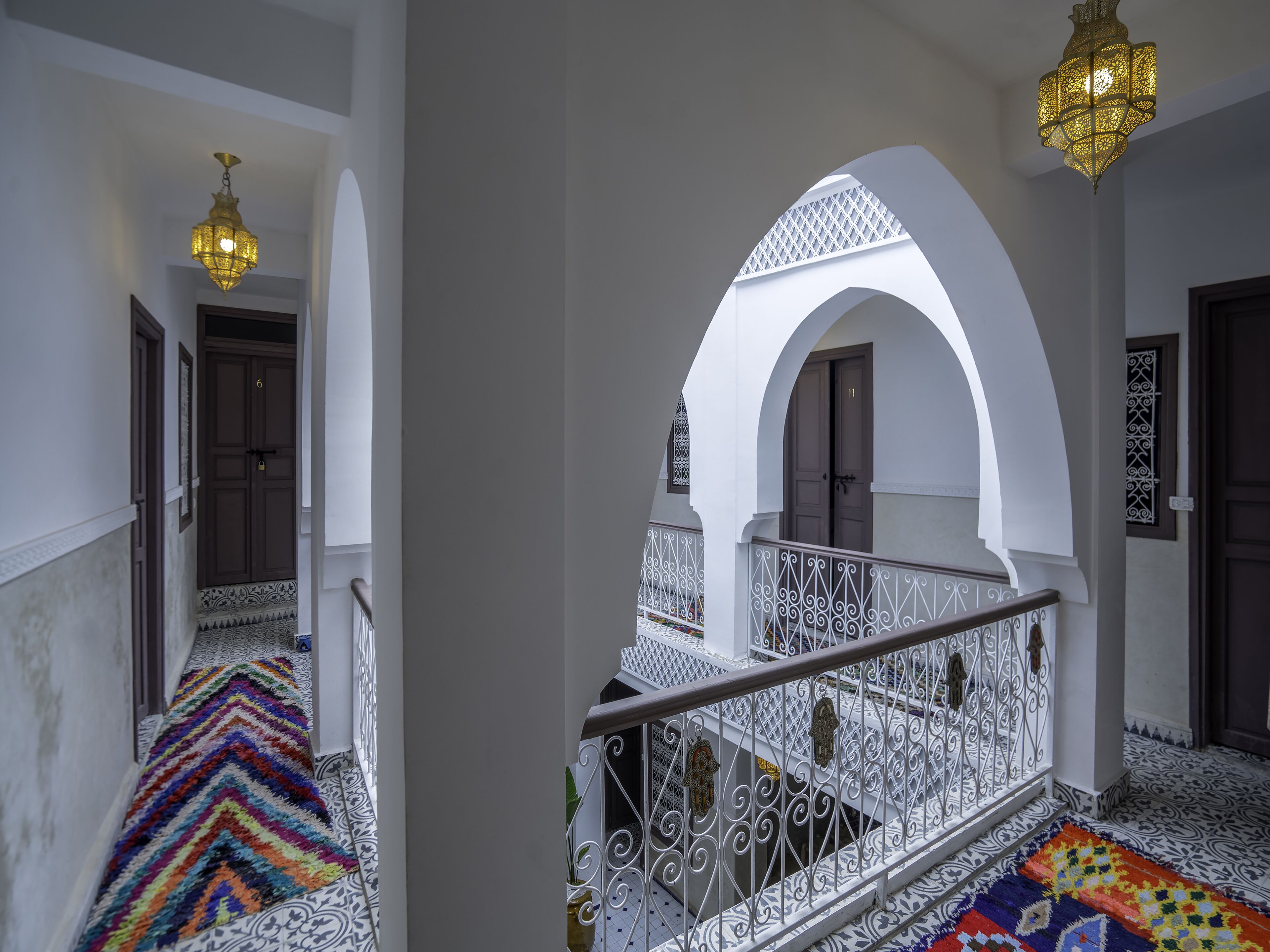 A staircase with white railings and a colorful carpet, leading to a room with a door marked '11'.