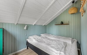 A room with a bed, a hanging lamp, and a shelf with a plant. - 3 bedroom cozy home in Toftlund (Toftlund)