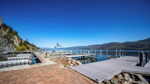 A lakeside dock with a clear view of the lake and distant mountains.