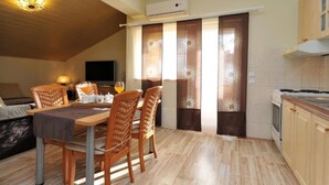 Un comedor acogedor con una mesa y sillas de madera, un televisor y una cocina con armarios de madera.