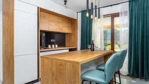 Une cuisine moderne avec des meubles en bois, un îlot central et des chaises de couleur turquoise.