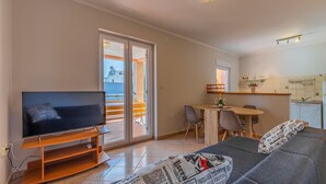 Ein Wohnzimmer mit Fernseher, Sofa und einem Teppich mit Zeitungsmotiv.