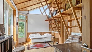 Um quarto aconchegante com uma cama, uma escrivaninha, uma estante e uma janela grande.