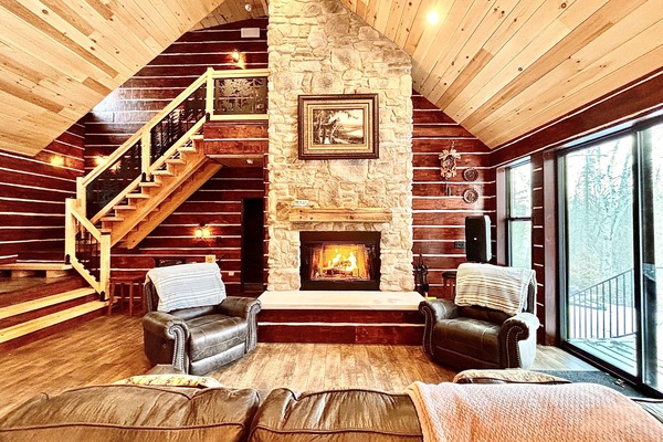 Open concept, family sitting area with large stone woodburning fireplace