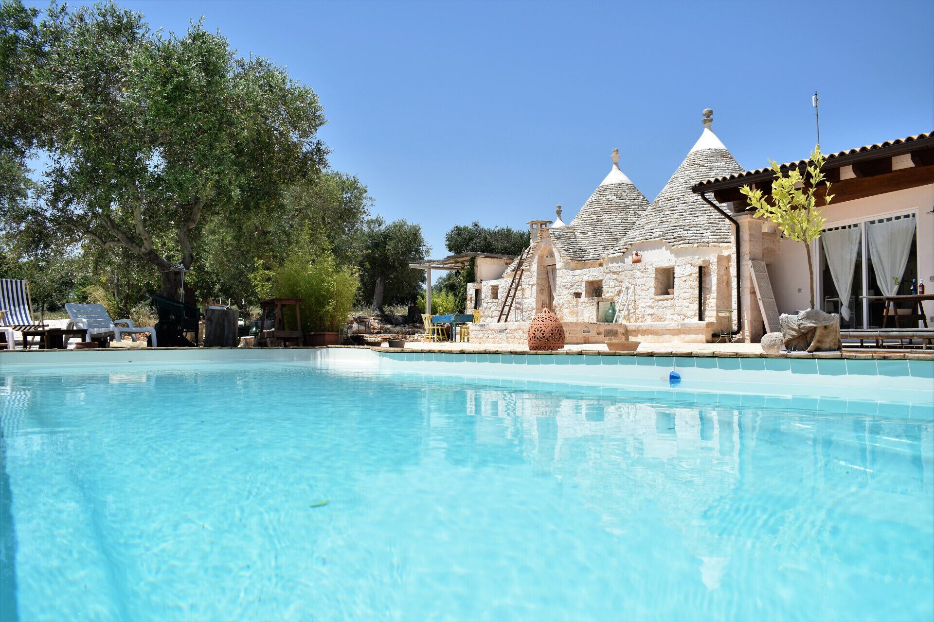 Une piscine avec des bâtiments en pierre en arrière-plan.