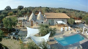 Une villa dotée d’une piscine, d’un espace extérieur aménagé et d’une structure blanche en forme de tente.