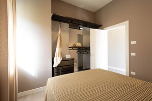 Un dormitorio con cama, cómoda, espejo y toalla colgada.