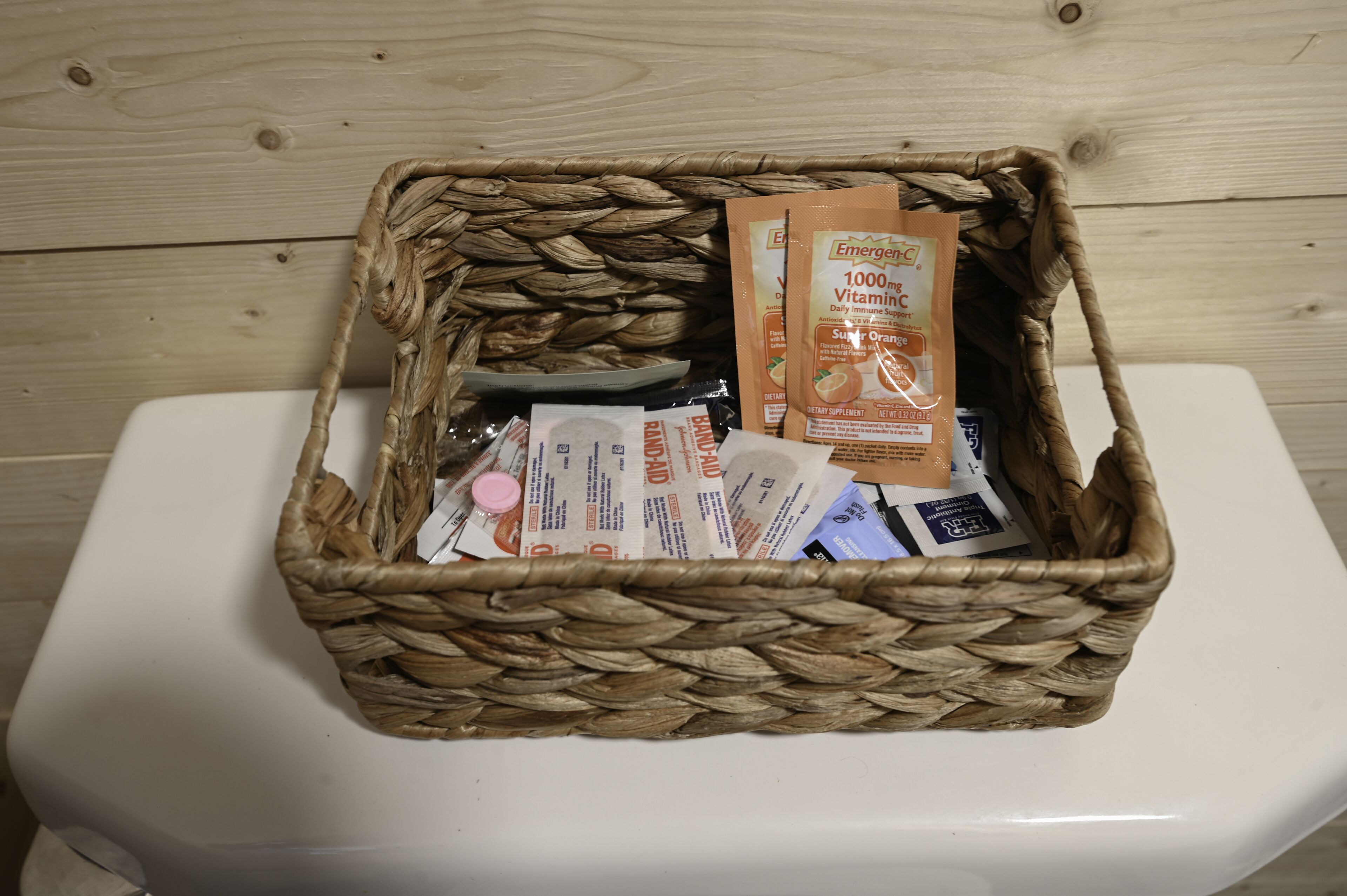 A wicker basket filled with various items on a white surface.
