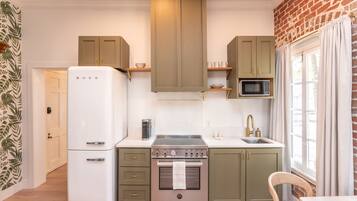 A kitchen with a refrigerator, stove, microwave, and wooden cabinets.