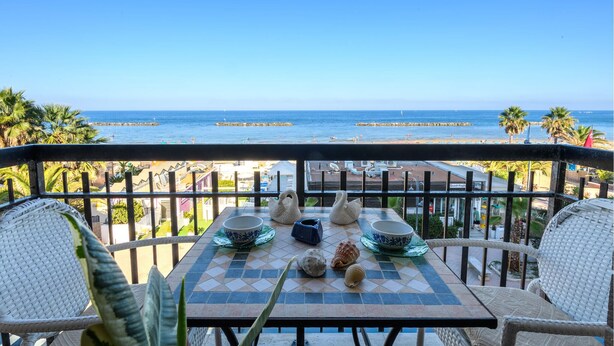 A table with a view of the beach and ocean. - Nice apartment in Porto San Giorgio (Porto San Giorgio)