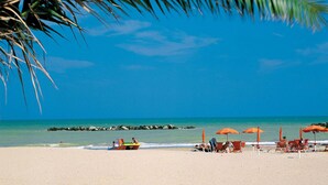 A beach with clear blue water, a few people, and orange umbrellas. - Nice apartment in Porto San Giorgio (Porto San Giorgio)