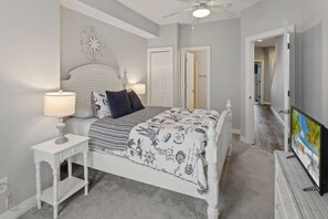 A bedroom with a bed, bedside tables, a ceiling fan, and a television. - CC302E Emerald Shores * Pool/Lazy River/Splash Pad (Kill Devil Hills)