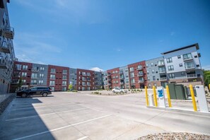 A multi-story residential building with a parking area in front. - Sleepover | Charming 1BD/1BA - Downtown Des Moines (Des Moines)