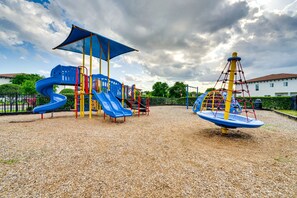 A playground with a blue slide, a climbing structure, and a seesaw. - 5BR Family Villa w/ Saltwater Pool near Disney (Davenport)