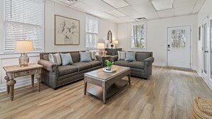 Ein Wohnzimmer mit zwei Sofas, einem Couchtisch und einer Tür.