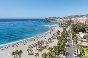 A coastal cityscape with a beach, palm-lined promenade, and buildings in the background. - Apartment 'Cielo Y Mar' with Sea View, Private Terrace and Wi-Fi (Almuñécar)