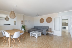 Een moderne woonkamer met een eettafel, bank en salontafel.