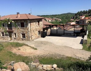 A stone building with a patio area, surrounded by a rural landscape.
