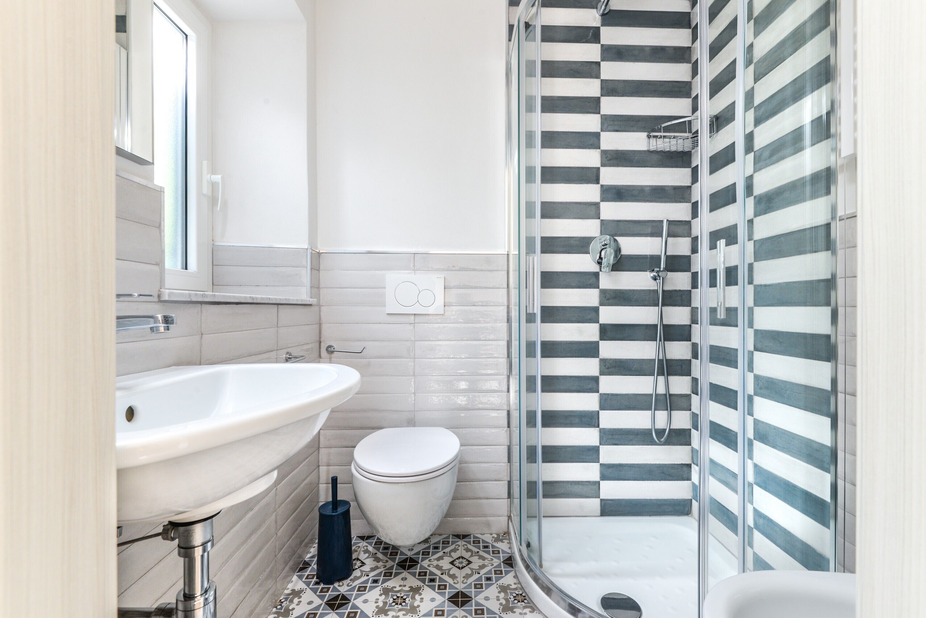 A bathroom with a white sink, toilet, and a glass-enclosed shower area.