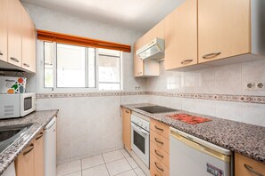 A kitchen with a microwave, stove, oven, and dishwasher.