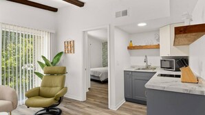 Eine moderne Wohnung mit Wohnbereich, Küche und Schlafzimmer.