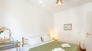 Une chambre à coucher avec un lit, une table de chevet, une lampe et un radiateur.