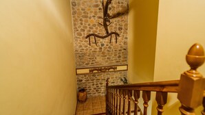 Una escalera con pared de piedra y barandilla de madera.