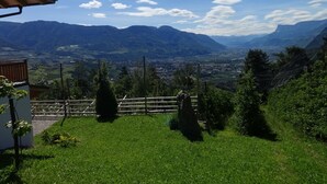 A mountainous landscape with a clear sky, a wooden fence, and a building with a sloped roof. - Apartment 'Oberötzbauer  Alpenrose' with Mountain View, Shared Garden and Wi-Fi (Tirol)
