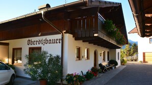 A building with the name 'Oberösterreich' on the facade, a wooden balcony with flowers, and a paved driveway. - Apartment 'Ober ötzbauer  Edelweiss' with Mountain View, Shared Garden and Wi-Fi (Tirol)