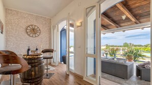 A room with a wooden barrel, a clock, and a view to an outdoor seating area. - 'Villa Sara' with Private Pool, Wi-Fi and Air Conditioning (Sorso)