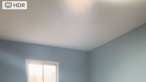 A bedroom with a bed, nightstands, a window, and a carpeted floor.