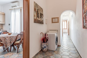 Un coin repas avec une table, des chaises et un vase contenant des parapluies.