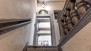 A staircase with a wooden handrail, a wall with a decorative molding, and a door leading to another room.