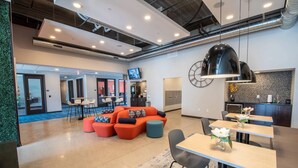 Un hall d’hôtel moderne comprenant un espace salon, une cuisine et un coin repas.