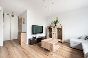 Relax in this stylish living room with a flat-screen TV, comfortable sofa, and ample storage.