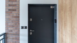 A black door with a numeric keypad, a keyhole, and a handle.