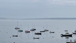 A calm body of water with several small boats anchored.