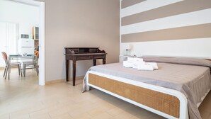 Un dormitorio con cama, escritorio y silla.