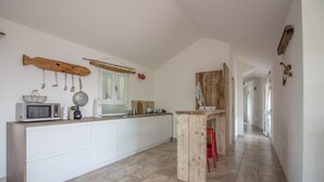 Una cocina con una decoración de pescado de madera, un microondas y un hervidor sobre la encimera.